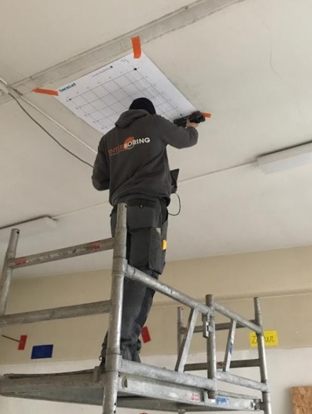 Betonchirurg scant het plafond om de wapening van de beton in kaart te brengen